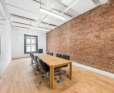 Conference room with a wood table and an exposed brick wall
