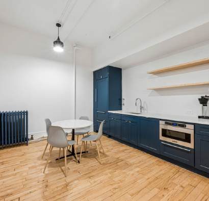 Kitchen with blue cabinetry and a small round table