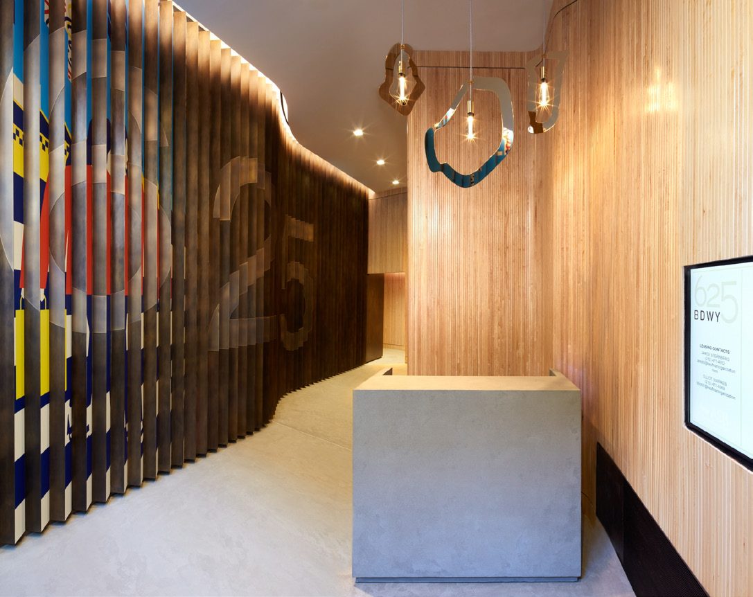 Lobby reception desk framed by curving wood slats