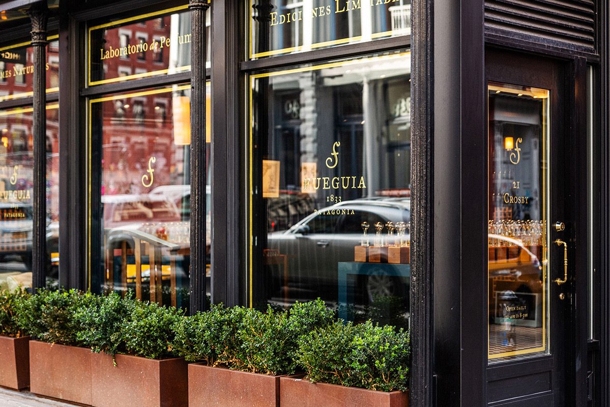 Storefront with black-framed windows and planters on a downtown street